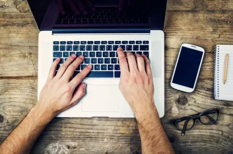 Image of hands working on a computer