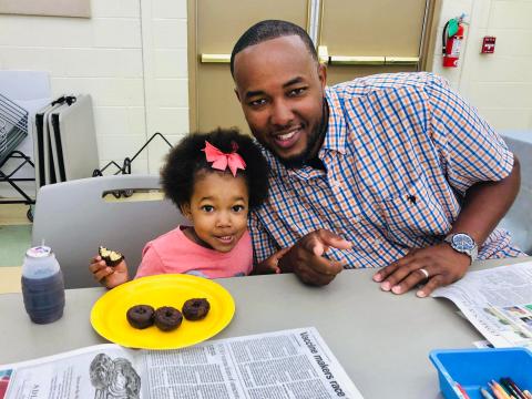 Image of child eating donuts with dad