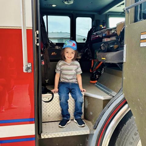 Image of kid sitting in fire truck