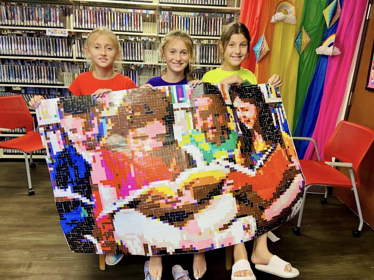 Image of girls holding up a sticker mural