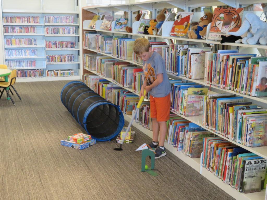 Image of kid playing mini golf in the library